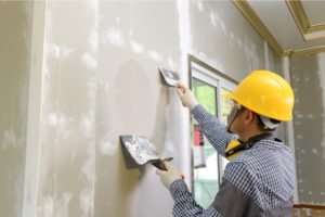 Construction Worker Plastering a Drywall