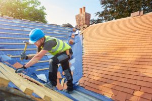 Worker replacing roof tiles