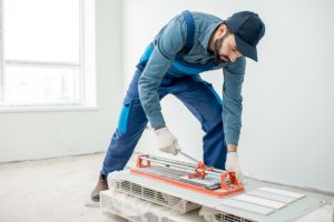 Workman cutting tiles indoors